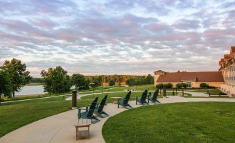 a patio area with several chairs and a table , surrounded by green grass and trees at Honey Creek Resort