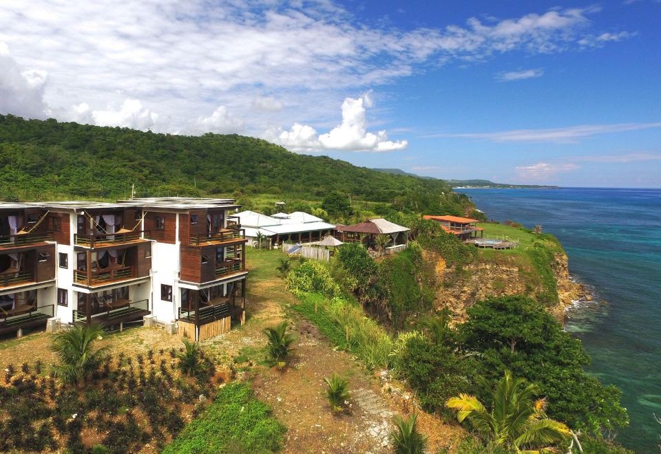 a group of houses situated on a hillside overlooking the ocean , with a view of the water in the background at The Sea Cliff Hotel Resort & Spa