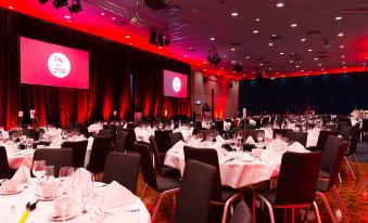 a large dining room with multiple tables and chairs set up for a formal event , possibly a wedding reception at Radisson Blu Hotel and Conference Cente, Oslo Alna