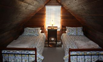 a small room with two beds , one on top of the other , and a window at Westbury Gingerbread Cottages