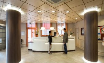 two men standing at a reception desk in a modern office , with each other 's hands at Hotel Saint Georges