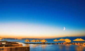 a serene beach scene with multiple yellow umbrellas floating on the water , creating a relaxing atmosphere at Djibouti Palace Kempinski