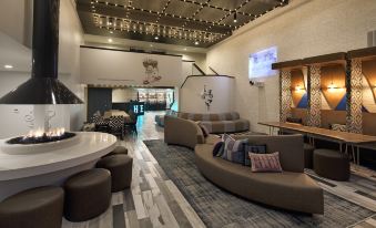 a modern lounge area with a variety of seating options , including couches , chairs , and a coffee table at Hotel Hermosa