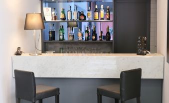 a modern bar with a marble counter , two black chairs , and a variety of bottles and glasses at Hotel Forum