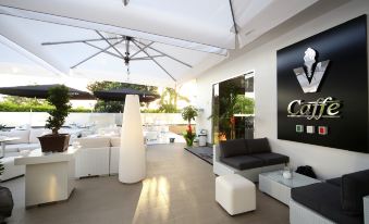 a modern living room with white furniture , including a couch , chairs , and a coffee table at Victoria Hotel