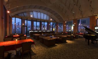 a large , dimly lit room with multiple couches and tables set up for a gathering at Hotel Verde