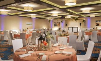 a well - decorated banquet hall with multiple tables set for a formal event , including centerpieces , flowers , and wine glasses at Bethany Beach Ocean Suites Residence Inn