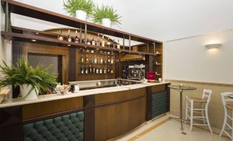 a modern bar with a wooden counter and various bottles of wine on the shelves at Hotel Cavaliere