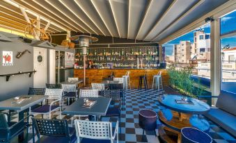 an outdoor restaurant with a bar area , where people are sitting and enjoying their meals at Lotus Inn