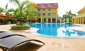 a large swimming pool with a red roof and several lounge chairs in front of a building at Country Roads