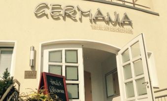 "a brick building with a sign that reads "" germanija "" prominently displayed on the front of the building" at Hotel Germania