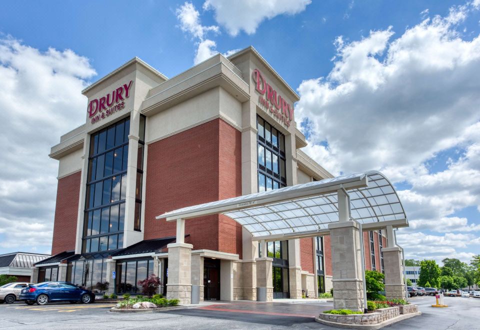 "a large hotel with a covered entrance and the words "" drury inn "" on its facade" at Drury Inn & Suites St. Louis Airport