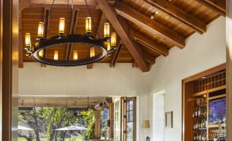 a restaurant with wooden beams and a skylight , featuring a bar area with tables and chairs at CordeValle