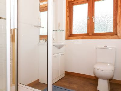 a modern bathroom with white walls , wooden doors , and large windows , as well as a toilet and sink at Moon Face