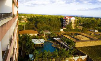 a bird 's eye view of a resort with a pool , buildings , and a view of the ocean at Rainbow Ruiru Resort