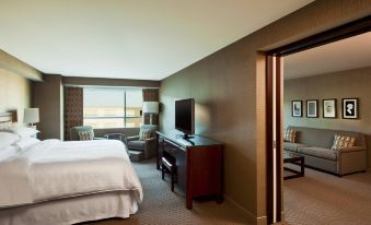 a hotel room with a king - sized bed , a flat - screen tv , a desk , and a window at Sheraton Valley Forge King of Prussia
