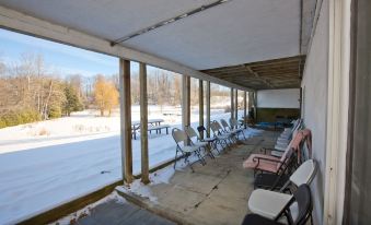 an outdoor seating area with rows of chairs and a view of snow - covered fields at White House Farm