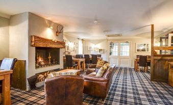 a cozy living room with a fireplace and couches , creating a warm and inviting atmosphere at Thames Head Inn