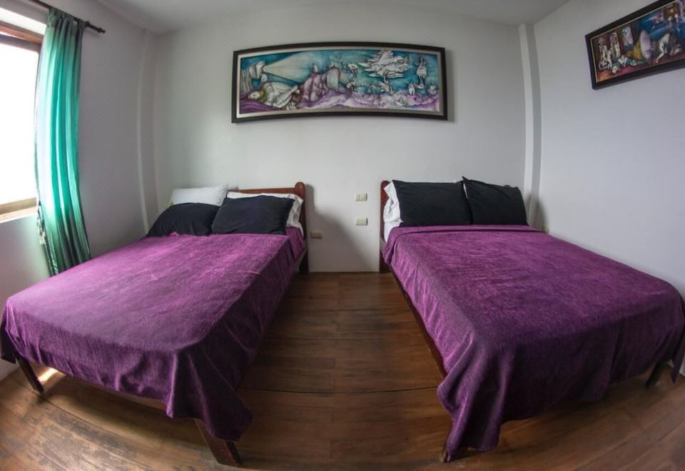 a bedroom with two beds , a painting on the wall , and wooden floors , giving it a cozy and inviting atmosphere at Makai
