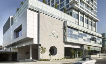 "a modern , white building with a sign that reads "" kidut "" is located on a street corner" at Element Vancouver Metrotown