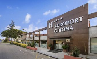 "the exterior of a large building with the sign "" aeroport girona "" prominently displayed on it" at Salles Hotel Aeroport de Girona