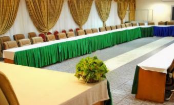 a long conference room with multiple tables and chairs arranged for a meeting or event at Hotel Palm Beach