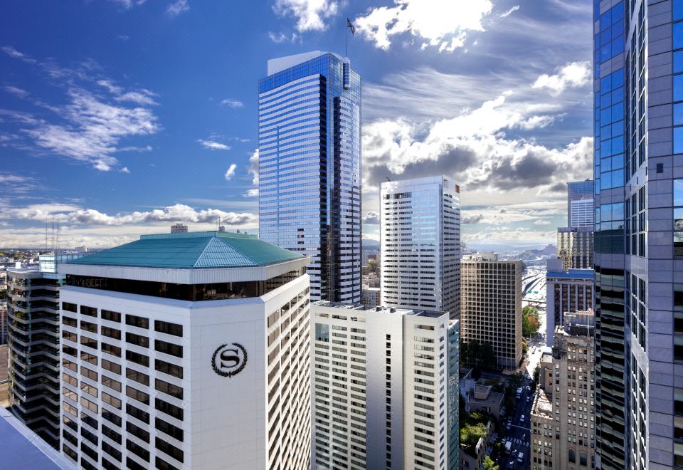 a cityscape with tall buildings , including a large white and blue skyscraper , against a blue sky at Sheraton Grand Seattle