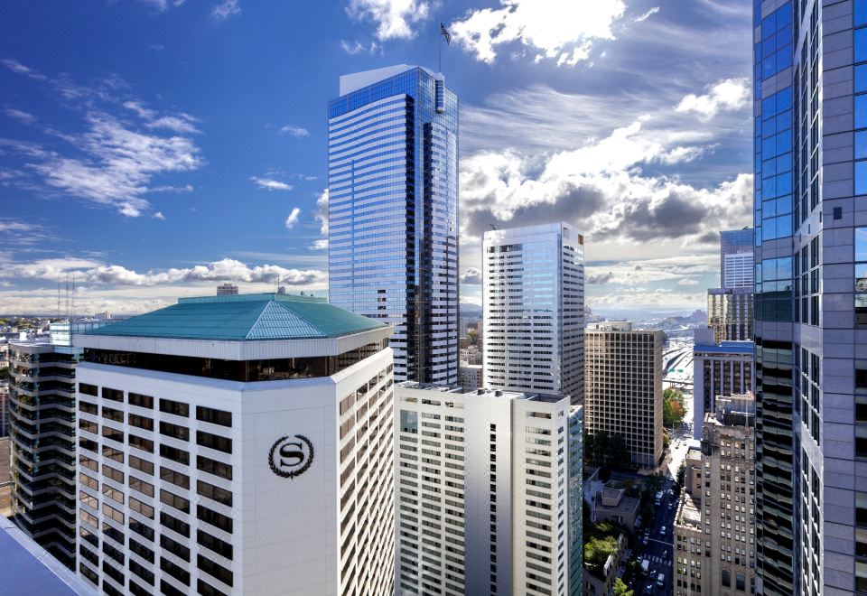 a city skyline with tall buildings , including the seattle seahawks logo , under a blue sky with clouds at Sheraton Grand Seattle