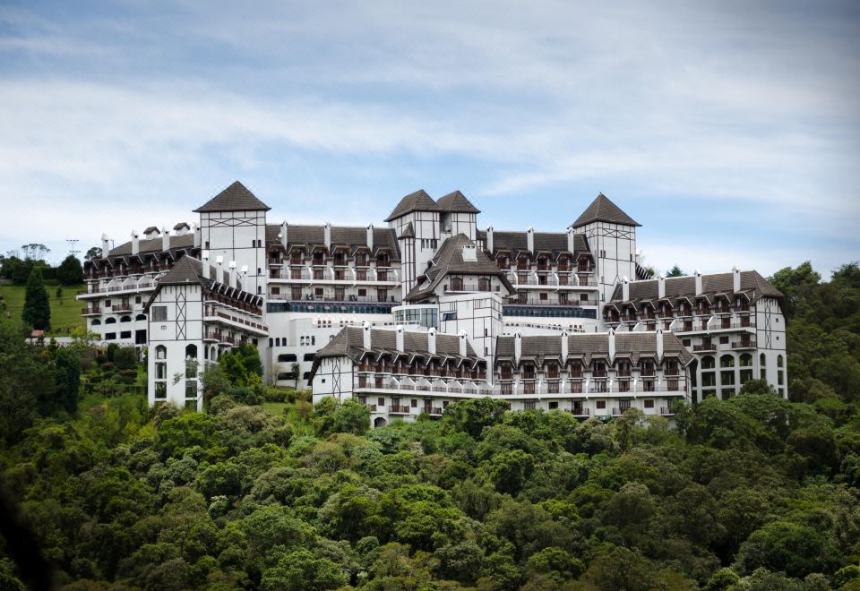 a large , white castle - like building surrounded by trees and grass , with a blue sky in the background at Hotel Home Green Home