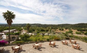 a patio area with several chairs and tables , providing a pleasant outdoor space for relaxation and dining at Monnaber NOU Finca Hotel & Spa