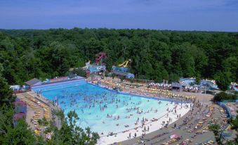 a large outdoor water park filled with people enjoying various water activities , such as swimming and playing in the pool at Hilton Garden Inn Philadelphia/Ft. Washington