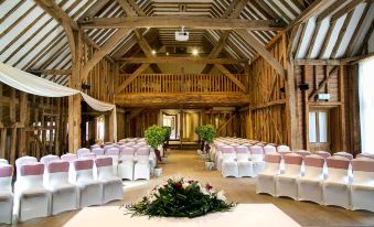 a large room with a wooden ceiling and chairs arranged for an event , possibly a wedding or a ceremony at Tewinbury