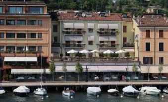 a row of boats floating in the water next to a row of colorful buildings at Hotel Duomo