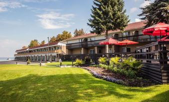 a large building with a red umbrella in front of it , surrounded by grass and trees at Ramada by Wyndham Jacksons Point