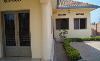 a brick house with a front door , surrounded by a courtyard with potted plants and a bird bath at Sport Corner