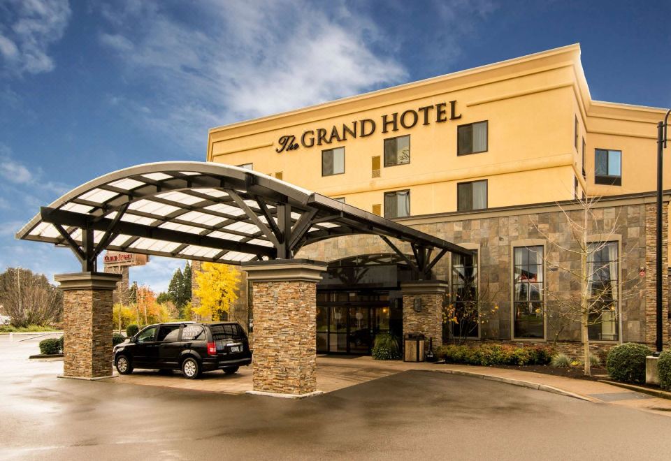 a large hotel building with a covered entrance and a car parked in front of it at Grand Hotel at Bridgeport