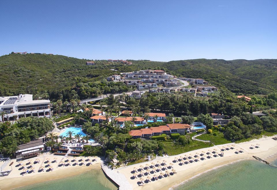 aerial view of a resort surrounded by trees , a beach , and a body of water at Eagles Palace