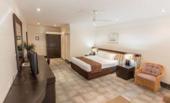 a modern bedroom with a large bed , two nightstands , and a tv on the wall at Karma Rottnest