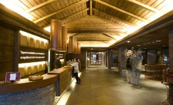 a large room with wooden ceiling and walls , featuring a man walking through a store at Hotel Val de Neu G.L.