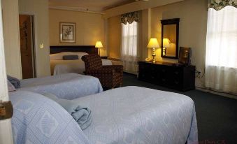 a hotel room with two beds , a window , and lamps on each side of the bed at Hotel Coolidge