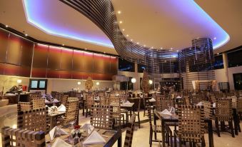 a large , modern restaurant with multiple dining tables and chairs , some of which are occupied by people at The Singhasari Resort Batu