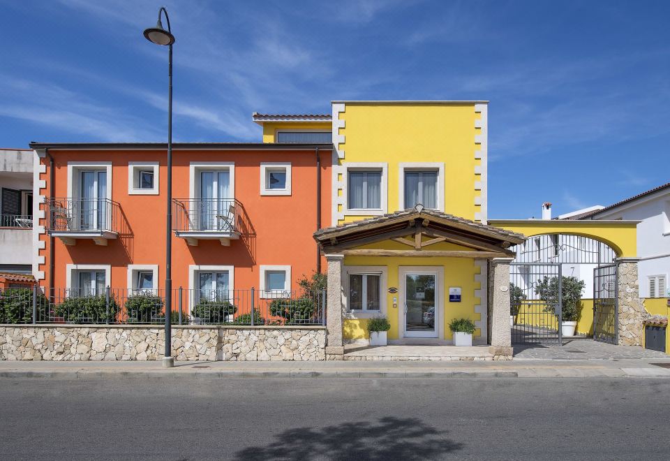 a yellow and orange building with a sign on the front , located on a street at Marin Hotel