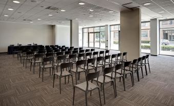 a large conference room with rows of chairs arranged in a semicircle , ready for a meeting or presentation at Inn Naples Airport