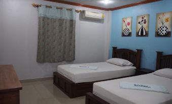 a small room with two beds , one on each side of the room , and a dresser in the corner at Rimmueng Resort