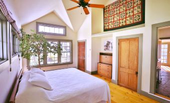 a spacious bedroom with a large bed , wooden floors , and a ceiling fan hanging from the ceiling at Whitford House