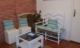 a living room with a brick wall , a couch , a chair , and a coffee table at Casa Rural la Plazuela de Mari