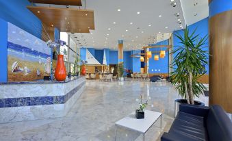a large hotel lobby with marble floors , blue walls , and various furniture arrangements such as couches and tables at Sol Costa Daurada