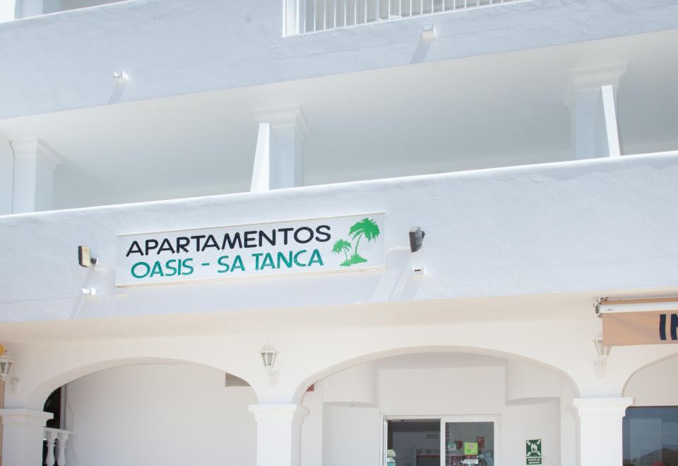 "the entrance of an apartment building with a sign above it that reads "" apartamentos oasis santaloca .""." at Typic Oasis Sa Tanca