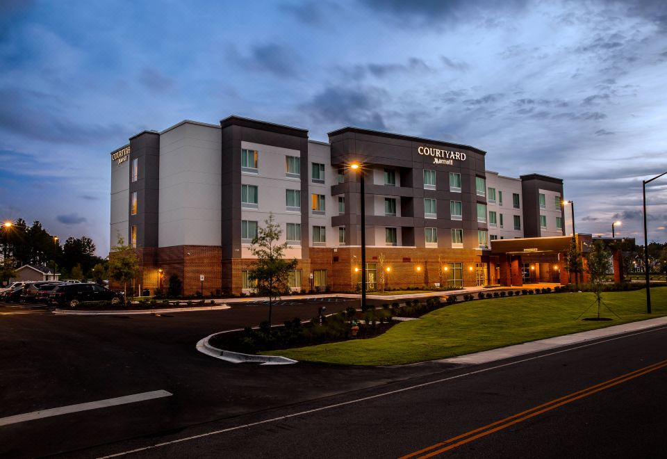 "a large building with the word "" courtyard "" on it , located next to a grassy area and surrounded by trees" at Courtyard Columbia Cayce