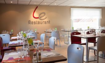 a dining room with several tables and chairs arranged for a group of people to enjoy a meal together at Campanile Villejust - ZA Courtaboeuf